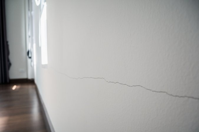 A crack running through a white interior wall.